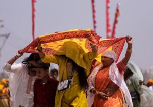 People shield themselves from the scorching heat on the banks of river Ganga. (Photo: PTI)