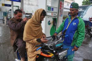 A motorcyclist buys fuel after the government increased fuel prices amid surging global oil prices due to the Iran war, in Peshawar, Pakistan, Friday, April 3, 2026. (AP Photo/Muhammad Sajjad)