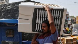 A worker carries an air cooler for delivery to a customer during the heatwave in Ahmedabad. (Photo: Reuters)