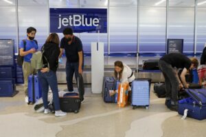 Travelers checking bags at a JetBlue counter in Fort Lauderdale, Fla.