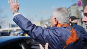 Reza Pahlavi waves to supporters after he was attacked with a red fluid following a news conference in Berlin, Germany. (Photo: AP)