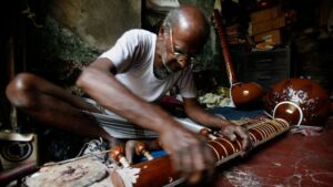 Suman Karmakar, an Indian instrument maker, works on a sitar inside a 50-year-old shop in the eastern Indian city of Kolkata. (Photo: Reuters)