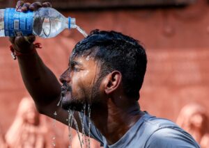 A man pours water on himself to cool down amid a heatwave in Jammu. (Photo: PTI)