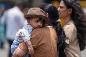 A woman covers a child amid heat during summer, in Mumbai, Maharashtra. (Photo: PTI)