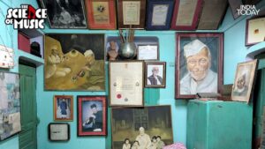 A wall in Ustad Bismillah Khan's Varanasi home, lined with portraits, certificates, and citations from across his lifetime, including the Bharat Ratna citation at the centre. The painting on the left shows him performing in profile, the very image of a man who lived for the instrument he played. (Photo: PTI)
